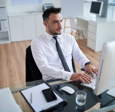 a man in a white shirt and tie is sitting at a desk