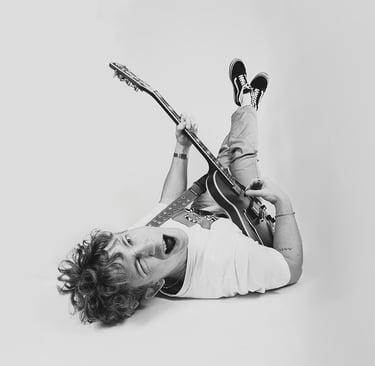 zwart-wit studioportret van gitarist met elektrische gitaar