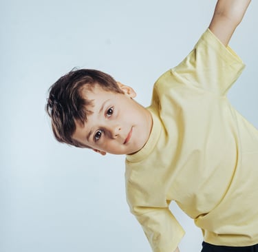 portrait of a young boy in a yellow shirt and black pants