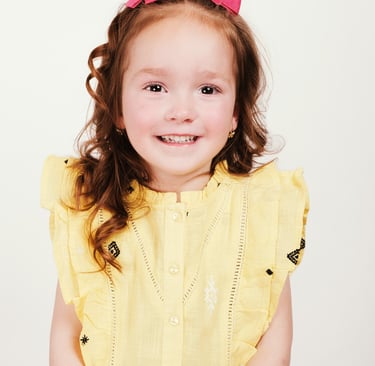 portrait of a little girl with a pink bow tie and a pink dress