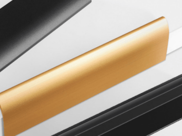 Hand installing a copper-toned aluminum alloy edge-mounted invisible handle on a white cabinet door