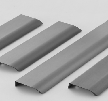 Multi-finish aluminum minimalist handles displayed against a white background, showcasing sleek arc design.