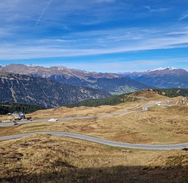 Kurvenreiche Bergstrasse durch die malerische Alpenlandschaft der Dolomiten unter blauem Himmel