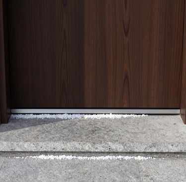 White rock salt spread across a stone doorstep and front door threshold for winter ice melting.