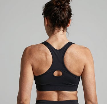 Back view of a woman wearing a black racerback sports bra for athletic fitness and gym workouts.