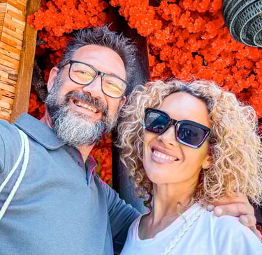 a sugar daddy and sugar baby standing in front of a red flowered wall