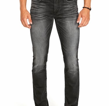 a man standing in a white shirt and jeans