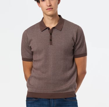 a man in a striped brown shirt and jeans