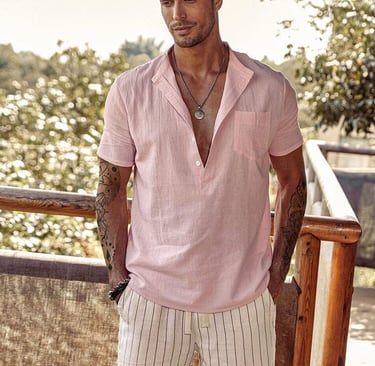 a man in a pink beach style shirt and white shorts