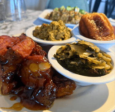 A plate of southern soul food featuring barbecue ribs, collard greens, cornbread, and stuffing.
