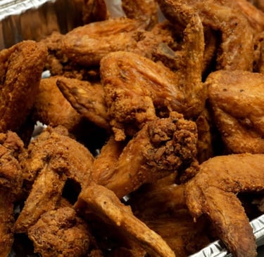 A silver tray filled with crispy, golden-brown deep-fried chicken wings.