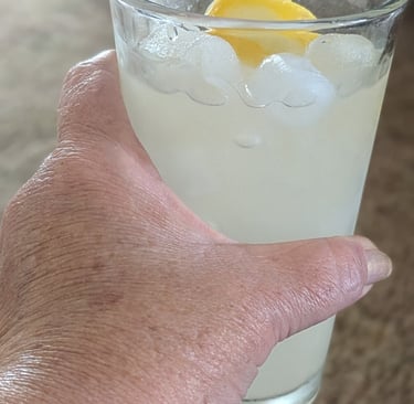 woman holding a glass of lemonade representing peaceful simple life after 50