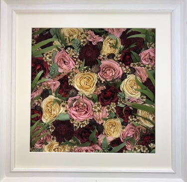 a flower wall style preserved wedding bouquet with long green leaves in a frame