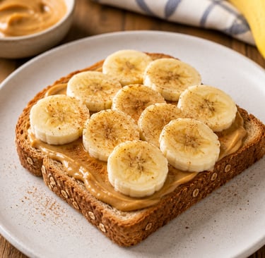 Peanut butter banana toast on whole grain bread sprinkled with cinnamon on a white plate.