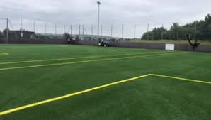 a man is playing tennis on a green field