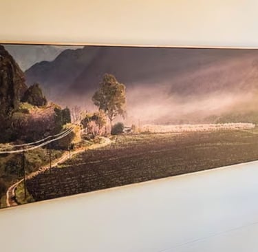 A large panoramic painting of a rural landscape in a modern interior painted by Martin Osner 