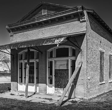 Empty and derelict small brick building in downtowon Weir, TX circa 2013. Perhaps a bank or post office in its day.