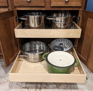 Kitchen cupboard pullouts holding pots and pans.
