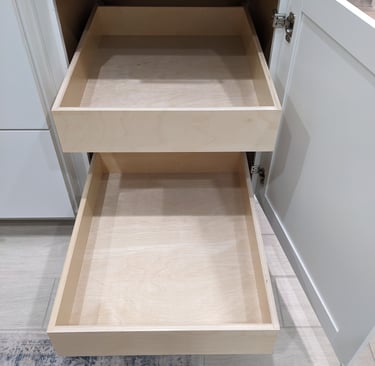 Two custom slide out shelves extended from a white kitchen cabinet.
