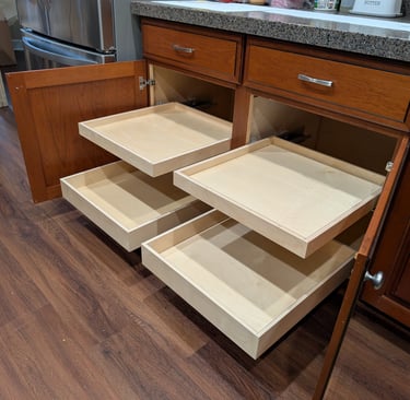 Four kitchen cabinet glide-out drawers extended from a large cabinet.