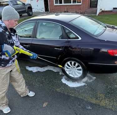 person pressure washing car tire