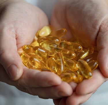 Mano que sostiene cápsulas de Omega 3