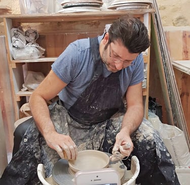 a man is throwing pottery plate on a wheel