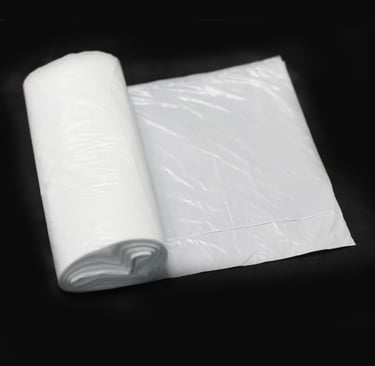 Rolo de saco para lixo branco no fundo preto.