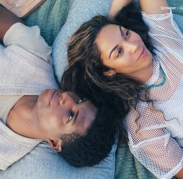 a man and woman laying on a blanket