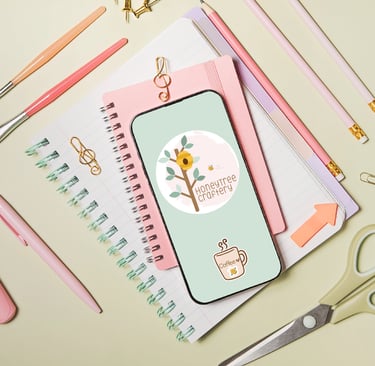 and iphone, notebooks, pencils and clips on a designers desk. HoneyTree Craftery logo.