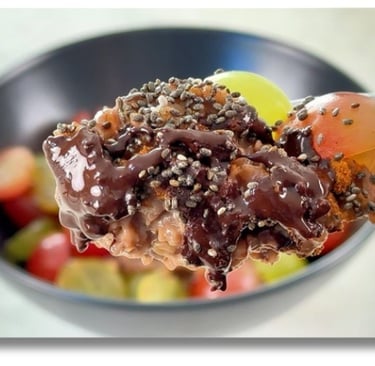 Chocolate porridge with grapes and dark chocolate — a warm, healthy Mediterranean breakfast.