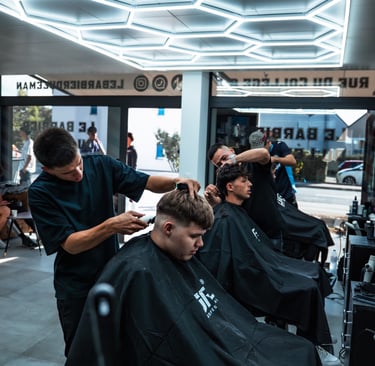 a man getting his hair cut by a barbershop