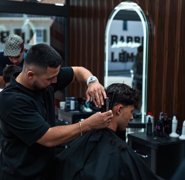 a man getting his hair cut by a barber