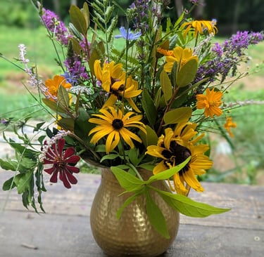 brass pitcher filled with seasonal blooms