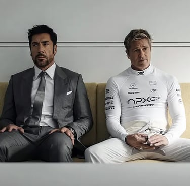 "Brad Pitt in a white racing suit sit side-by-side on a beige couch in a