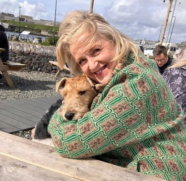 smiling blonde woman cuddling a dog