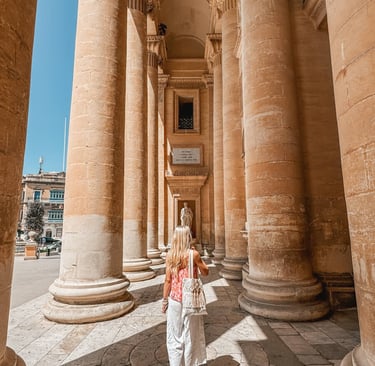 girl walking through mosta rotunda columns