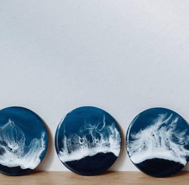 three plates with waves on it with the paint