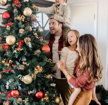 Christmas tree beside a family members standing 