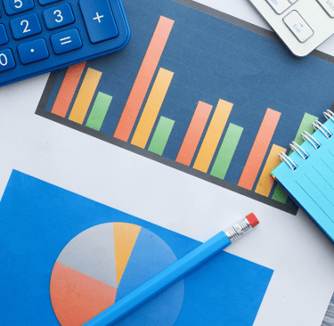 a pencil a calculator a notebook and a chart on the table