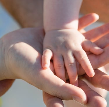 parents holding baby's hand