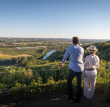 a couple of people standing on a hill overlooking a dordogne valley