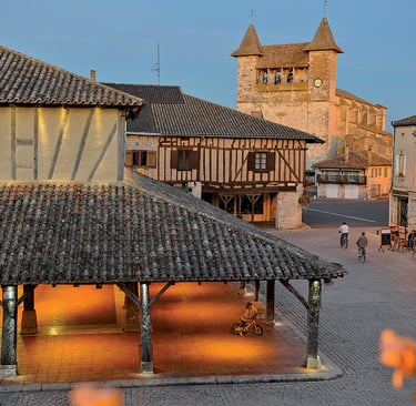 a town square with a clock tower and a clock tower Villeréal market