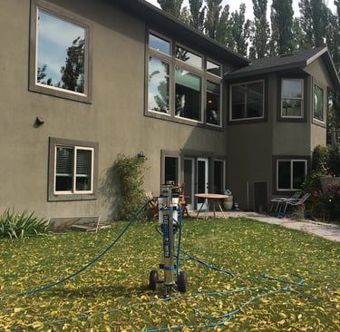 a man is using a hose to clean the lawn