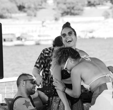 to women laughing raciously on a boat party sourrounded by people