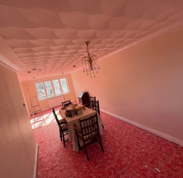 A freshly painted lounge with a antique dining table and chandelier 