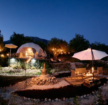Osvetljeni glamping kupola i dvorište u večernjoj atmosferi