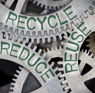 Metal gears with "Reduce," "Reuse," and "Recycle" in green, symbolizing sustainability.