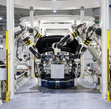 A high-tech automotive manufacturing facility with multiple robotic arms assembling a vehicle.