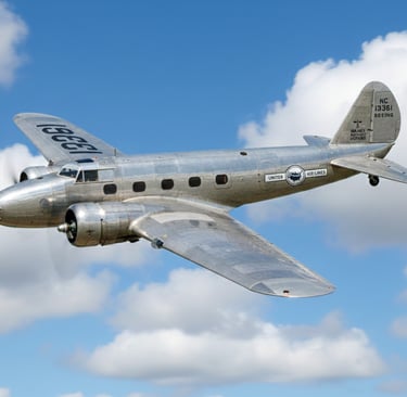 a silver airplane flying through the sky